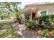 Charming front porch with lovely landscaping and a vibrant red door at 11802 Foxrun Ln, Temple Terrace, FL 33617