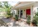 Inviting front porch featuring a red door and well-maintained landscaping at 11802 Foxrun Ln, Temple Terrace, FL 33617
