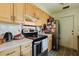 Kitchen area with black appliances, light wood cabinetry, and white countertops at 11802 Foxrun Ln, Temple Terrace, FL 33617