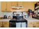 Kitchen with ample storage space with light wood cabinets and black appliances at 11802 Foxrun Ln, Temple Terrace, FL 33617