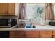 Kitchen area with stainless sink, natural light from the window, and ample counter space at 11802 Foxrun Ln, Temple Terrace, FL 33617