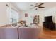 Bright living room with a large sectional, a ceiling fan, hardwood floors, and a TV for comfortable entertainment at 11802 Foxrun Ln, Temple Terrace, FL 33617