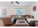 Comfortable living room showcasing a large gray sectional sofa, patterned ottoman, and bright natural light from the windows at 11802 Foxrun Ln, Temple Terrace, FL 33617