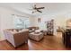 Inviting living room with a large sectional, hardwood floors, stylish decor, and a view of a connected room at 11802 Foxrun Ln, Temple Terrace, FL 33617