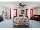 Main bedroom featuring a ceiling fan and multiple windows with red and white curtains at 11802 Foxrun Ln, Temple Terrace, FL 33617