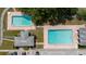 Overhead view of community pools with brickwork, cabana and adjacent parking lot at 11802 Foxrun Ln, Temple Terrace, FL 33617