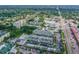 Aerial view of the community featuring a pool, landscaping, parking, and residential buildings surrounded by trees at 1235 S Highland Ave # 2-207, Clearwater, FL 33756