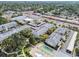 An aerial view shows the condo buildings, parking, and a shuffleboard court with easy access to nearby shopping centers at 1235 S Highland Ave # 2-207, Clearwater, FL 33756