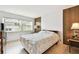 Bedroom featuring wood paneling accent wall, wood floors, large windows, and a neutral color scheme at 1235 S Highland Ave # 2-207, Clearwater, FL 33756