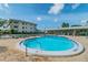 Community pool with clear blue water surrounded by lounge chairs and lush landscaping, offering a relaxing outdoor space at 1235 S Highland Ave # 2-207, Clearwater, FL 33756
