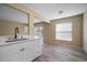 Bright kitchen with sink, white cabinets, and wood-look floors at 12419 Dawn Vista Dr, Riverview, FL 33578