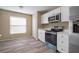 Kitchen with stainless steel appliances, white cabinets, and wood-look floors at 12419 Dawn Vista Dr, Riverview, FL 33578