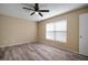 Bedroom featuring stylish ceiling fan, wood-look flooring, and a sun-filled window with white trim at 12419 Dawn Vista Dr, Riverview, FL 33578