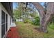 A view of the well maintained backyard landscaping, with mature trees and mulch ground cover at 12601 Stone House Loop, Hudson, FL 34667