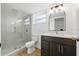 Bathroom featuring glass shower enclosure, vanity with dark cabinets and sleek countertop at 12601 Stone House Loop, Hudson, FL 34667