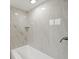 Bathroom featuring tiled shower and tub combination with white porcelain tub at 12601 Stone House Loop, Hudson, FL 34667