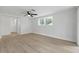 Bedroom featuring wood floors, ceiling fan, and window with blinds at 12601 Stone House Loop, Hudson, FL 34667
