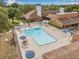 Aerial view of the community pool area, highlighting the pool, lounge chairs, and surrounding landscaping at 12601 Stone House Loop, Hudson, FL 34667