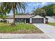 Well-maintained single Gathering home with a manicured lawn, palm tree, and an attached two-car garage at 12601 Stone House Loop, Hudson, FL 34667