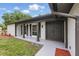 Close-up view of the front porch with decorative columns, double doors, and fresh landscaping at 12601 Stone House Loop, Hudson, FL 34667