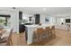 Modern kitchen boasts a large island with barstool seating, sleek cabinetry, and stainless steel appliances at 12601 Stone House Loop, Hudson, FL 34667