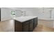 Spacious kitchen island with dark cabinets and light countertops, offering ample storage and workspace at 12601 Stone House Loop, Hudson, FL 34667