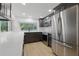 Modern kitchen with stainless steel appliances, dark wood cabinets, white countertops, and backsplash at 12601 Stone House Loop, Hudson, FL 34667