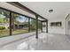 A bright sunroom featuring large windows, view of yard, glossy floors, and a bar height countertop with door to back at 12601 Stone House Loop, Hudson, FL 34667