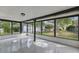 A spacious sunroom featuring large windows with backyard view and glossy floors allowing natural light to illuminate the space at 12601 Stone House Loop, Hudson, FL 34667