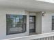 Exterior view of condo entrance featuring a window with blinds and the front door on the balcony at 1332 Pasadena S Ave # 503, South Pasadena, FL 33707