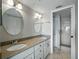 Bathroom featuring a granite vanity with dual sinks and a glass door shower at 1332 Pasadena S Ave # 503, South Pasadena, FL 33707