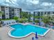 A beautiful community pool featuring lounge chairs, umbrellas, and lush landscaping at 1332 Pasadena S Ave # 503, South Pasadena, FL 33707