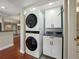 Modern laundry area with stackable washer/dryer and white cabinets at 1332 Pasadena S Ave # 503, South Pasadena, FL 33707
