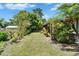 Backyard area features a screened-in porch, decorative plants, and green grassy area surrounded by foliage at 1349 New Bedford Dr # 6, Sun City Center, FL 33573