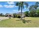 Beautifully landscaped front yard with mature trees and lush green grass, enhancing curb appeal at 1349 New Bedford Dr # 6, Sun City Center, FL 33573