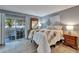 Serene main bedroom with sliding glass doors to patio, neutral decor, and wood-look floors at 1349 New Bedford Dr # 6, Sun City Center, FL 33573