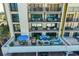 Exterior view of condo balconies with ample seating and patio furniture overlooking the pool and landscape at 1480 Gulf Blvd # 109, Clearwater Beach, FL 33767