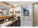Elegant bathroom with a granite countertop vanity, a large mirror, and a glass-enclosed shower at 1480 Gulf Blvd # 109, Clearwater Beach, FL 33767