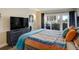 Comfortable bedroom with balcony access, a large TV, and tasteful decor for relaxation at 1480 Gulf Blvd # 109, Clearwater Beach, FL 33767