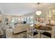 Open-concept living and dining area with stylish furnishings and modern lighting fixtures at 1480 Gulf Blvd # 109, Clearwater Beach, FL 33767