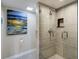 Updated bathroom features a frameless glass door shower with stone-look tiling and chrome fixtures at 1480 Gulf Blvd # 109, Clearwater Beach, FL 33767