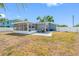 A large backyard is complete with white fencing, new landscaping, and a screened in patio at 14884 Cromwell Dr, Clearwater, FL 33764