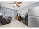 Bedroom with window offering great natural light, furnished with ceiling fan, recliner chair, refrigerator and a writing desk at 14884 Cromwell Dr, Clearwater, FL 33764