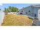 A fenced backyard has a patio, tropical foliage, and home exterior with windows at 14884 Cromwell Dr, Clearwater, FL 33764