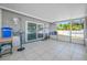 A tile floored screened patio offers views of the backyard, seating, and an entrance to the home at 14884 Cromwell Dr, Clearwater, FL 33764