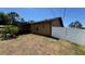 View of the back of the house showing the backyard, screened porch and white fence at 150 Tompkins St, Port Charlotte, FL 33954