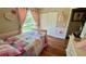 Bright bedroom showcasing hardwood floors and pink accents, offering a cozy and inviting space at 150 Tompkins St, Port Charlotte, FL 33954