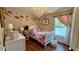 Well-decorated bedroom with hardwood floors, a white bed frame, and charming floral accents, perfect for a young  at 150 Tompkins St, Port Charlotte, FL 33954