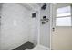 Nicely remodeled bathroom with white marble style tiled walls and a shower with gray tiled floor at 17519 Drake Ct, Lutz, FL 33559