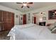 Well-lit bedroom featuring wood-look floors, a plush area rug, and an ensuite door on the far wall at 17519 Drake Ct, Lutz, FL 33559